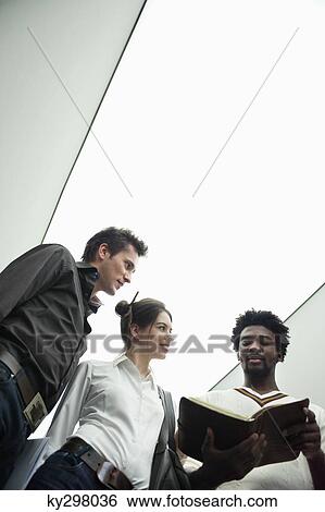 Business executives standing in the corridor of an office View Large Photo Image Stock Photograph - Business executives standing in the corridor of an office. Fotosearch