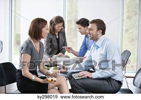 Stock Photo - Business executives talking to each other. Fotosearch