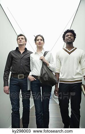 Business executives walking in the corridor of an office View Large Photo Image Stock Image - Business executives walking in the corridor of an office. Fotosearch