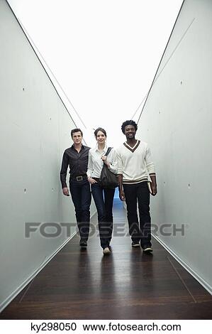 Stock Image - Business executives walking in the corridor of an office. Fotosearch
