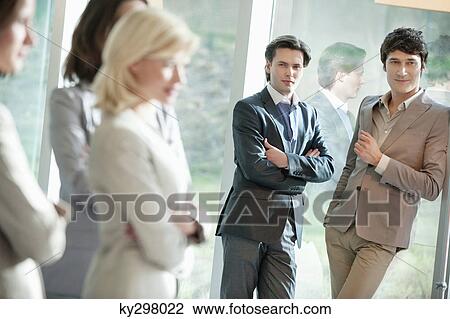 Two businessmen looking at their female colleagues View Large Photo Image Stock Image - Two businessmen looking at their female colleagues. Fotosearch