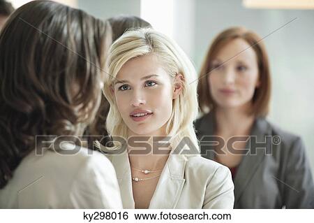 Two businesswomen discussing with each other View Large Photo Image Stock Photograph - Two businesswomen discussing with each other. Fotosearch