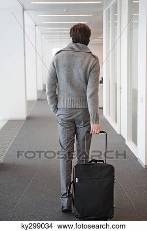 Businessman carrying his luggage View Large Photo Image Picture - Businessman carrying his luggage. Fotosearch