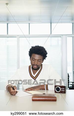 Businessman doing paperwork while listening radio View Large Photo Image Stock Image - Businessman doing paperwork while listening radio. Fotosearch