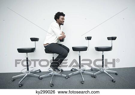 Businessman sitting on a chair and smiling View Large Photo Image Stock Photograph - Businessman sitting on a chair and smiling. Fotosearch