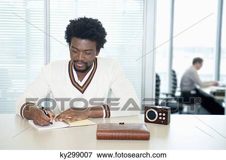 Businessmen doing paperwork and listening to a radio in an office View Large Photo Image Stock Photo - Businessmen doing paperwork and listening to a radio in an office. Fotosearch