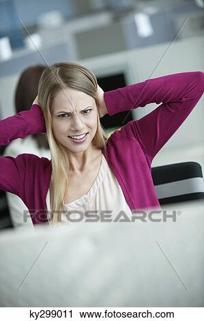 Businesswoman covering her ears in an office View Large Photo Image Stock Image - Businesswoman covering her ears in an office. Fotosearch