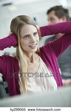 Businesswoman covering her ears in an office View Large Photo Image Stock Photography - Businesswoman covering her ears in an office. Fotosearch