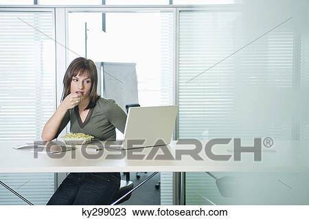 Businesswoman eating bean sprouts and using a laptop View Large Photo Image Stock Image - Businesswoman eating bean sprouts and using a laptop. Fotosearch
