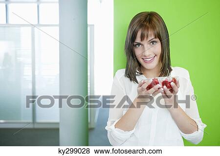 Stock Photo - Businesswoman holding a bowl of cherry tomatoes. Fotosearch