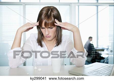 Stock Image - Businesswoman suffering from a headache. Fotosearch