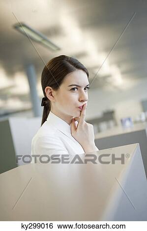 Businesswoman with finger on her lips View Large Photo Image Stock Photograph - Businesswoman with finger on her lips. Fotosearch