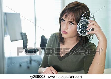 Portrait of a businesswoman holding an alarm clock View Large Photo Image Stock Image - Portrait of a businesswoman holding an alarm clock. Fotosearch