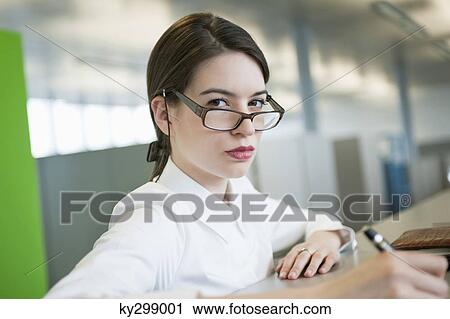 Portrait of a businesswoman looking over eyeglasses View Large Photo Image Stock Image - Portrait of a businesswoman looking over eyeglasses. Fotosearch