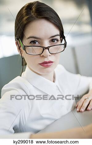 Portrait of a businesswoman looking over eyeglasses View Large Photo Image Stock Photo - Portrait of a businesswoman looking over eyeglasses. Fotosearch