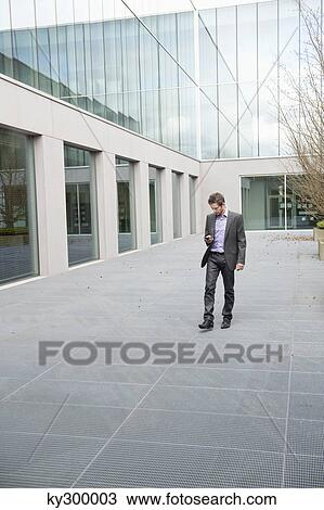Businessman text messaging on a mobile phone View Large Photo Image Stock Image - Businessman text messaging on a mobile phone. Fotosearch