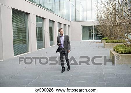 Stock Photograph - Businessman text messaging on a mobile phone. Fotosearch