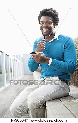 Man listening to an MP3 player View Large Photo Image Stock Photo - Man listening to an MP3 player. Fotosearch