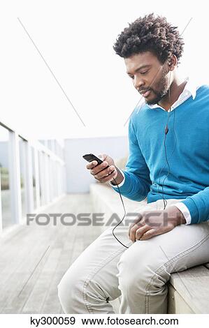 Man listening to an MP3 player View Large Photo Image Stock Photo - Man listening to an MP3 player. Fotosearch