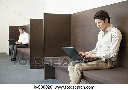 Two businessmen working in an office View Large Photo Image Stock Image - Two businessmen working in an office. Fotosearch