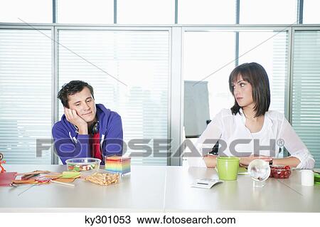Businessman and a businesswoman sitting together with food on table View Large Photo Image Stock Image - Businessman and a businesswoman sitting together with food on table. Fotosearch