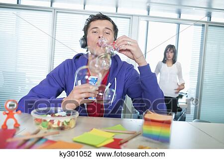 Businessman blowing bubbles in an office View Large Photo Image Stock Image - Businessman blowing bubbles in an office. Fotosearch