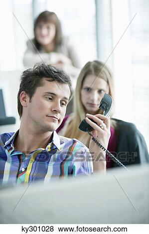 Businessman holding telephone receiver and looking angry View Large Photo Image Stock Photo - Businessman holding telephone receiver and looking angry. Fotosearch