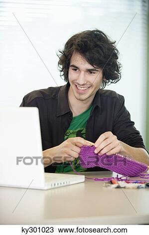 Businessman knitting in front of a laptop View Large Photo Image Stock Image - Businessman knitting in front of a laptop. Fotosearch