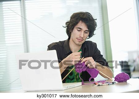 Businessman knitting in front of a laptop View Large Photo Image Stock Photo - Businessman knitting in front of a laptop. Fotosearch