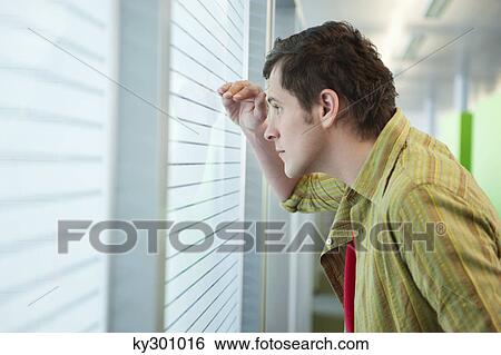 Stock Photograph - Businessman looking through a window. Fotosearch