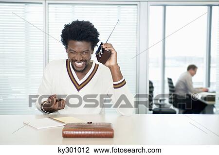 Businessmen listening to a radio while working in office View Large Photo Image Stock Image - Businessmen listening to a radio while working in office. Fotosearch