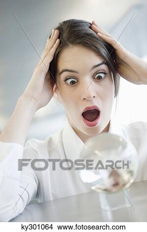 Businesswoman looking at a crystal ball and looking shocked View Large Photo Image Picture - Businesswoman looking at a crystal ball and looking shocked. Fotosearch