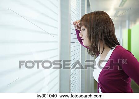 Businesswoman looking through a window View Large Photo Image Stock Image - Businesswoman looking through a window. Fotosearch