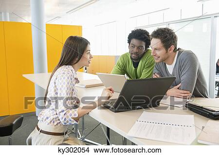 Picture - Business executives using laptops in an office. Fotosearch