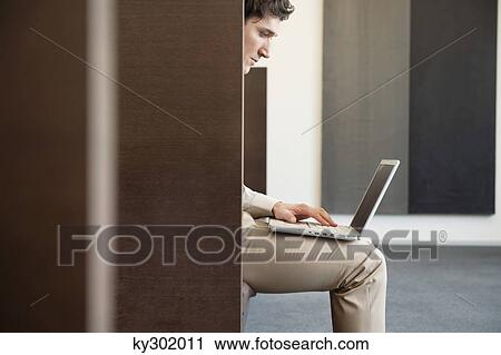 Businessman working on a laptop in an office View Large Photo Image Stock Image - Businessman working on a laptop in an office. Fotosearch