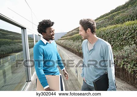 Friends discussing on a boardwalk View Large Photo Image Picture - Friends discussing on a boardwalk. Fotosearch