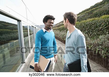 Stock Photograph - Friends discussing on a boardwalk. Fotosearch