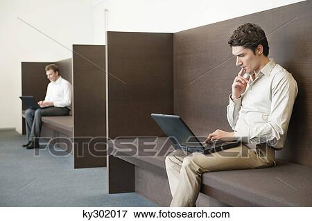 Two businessmen working in an office View Large Photo Image Stock Photo - Two businessmen working in an office. Fotosearch