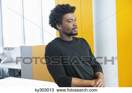 Businessman standing in an office View Large Photo Image Stock Image - Businessman standing in an office. Fotosearch