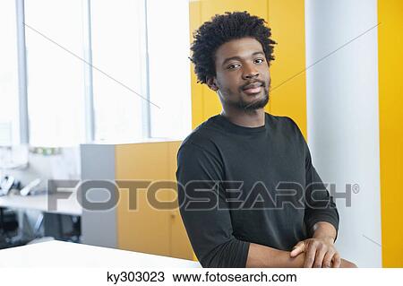 Businessman standing in an office View Large Photo Image Stock Image - Businessman standing in an office. Fotosearch