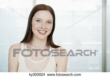 Businesswoman smiling in an office View Large Photo Image Picture - Businesswoman smiling in an office. Fotosearch