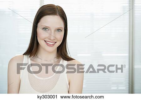 Businesswoman smiling in an office View Large Photo Image Stock Image - Businesswoman smiling in an office. Fotosearch