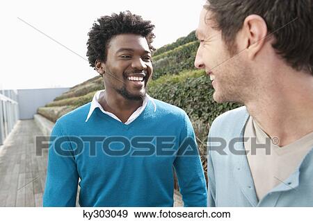 Friends discussing on a boardwalk View Large Photo Image Stock Photo - Friends discussing on a boardwalk. Fotosearch