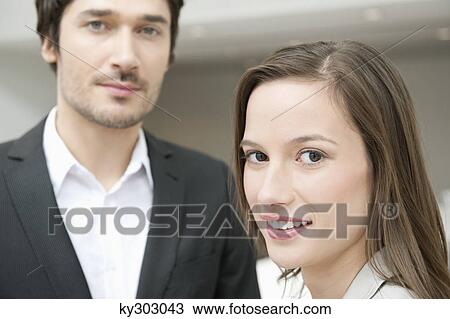 Portrait of a businesswoman smiling with her colleague beside her View Large Photo Image Stock Image - Portrait of a businesswoman smiling with her colleague beside her. Fotosearch