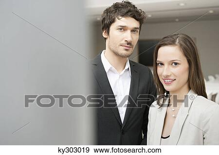 Stock Photo - Portrait of a businesswoman smiling with her colleague beside her. Fotosearch