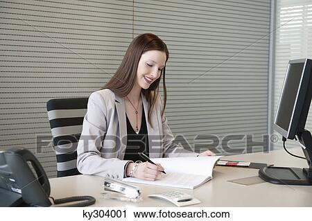 Businesswoman doing paperwork in an office View Large Photo Image Stock Image - Businesswoman doing paperwork in an office. Fotosearch