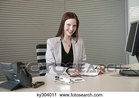 Businesswoman doing paperwork in an office View Large Photo Image Stock Image - Businesswoman doing paperwork in an office. Fotosearch