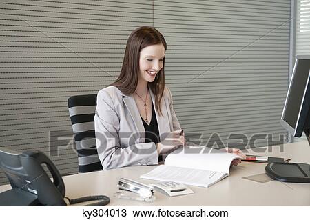 Businesswoman doing paperwork in an office View Large Photo Image Stock Image - Businesswoman doing paperwork in an office. Fotosearch