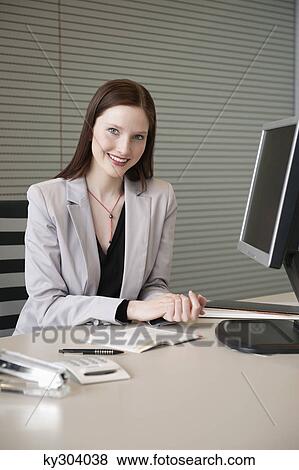 Stock Photo - Businesswoman doing paperwork in an office. Fotosearch