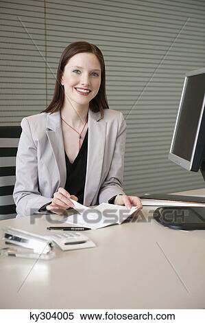 Businesswoman doing paperwork in an office View Large Photo Image Stock Photography - Businesswoman doing paperwork in an office. Fotosearch